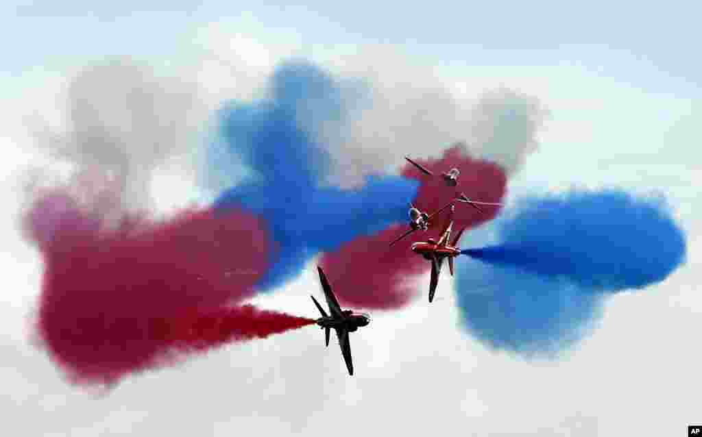 Tim akrobat Angkatan Udara Inggris 'Red Arrows' tampil dalam atraksi sebelum kejuaraan Grand Prix Formula 1 di sirkuit balap Silverstone, Inggris.