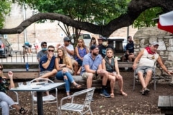 La gente se sienta en un bar al aire libre y come en medio del brote global de coronavirus (COVID-19), en Austin, Texas, EE.UU., el 28 de junio de 2020. REUTERS / Sergio Flores