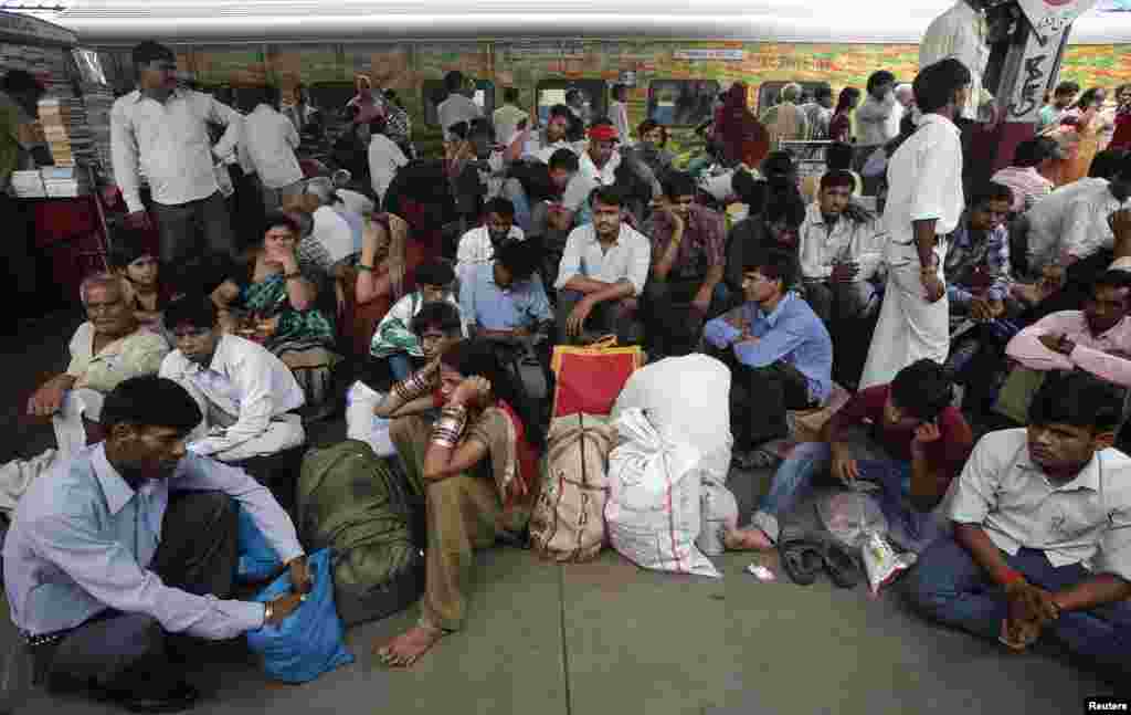 Passengers sit on a platform for their train to arrive as they wait for electricity to be restored at a railway station in New Delhi, July 31, 2012. .
