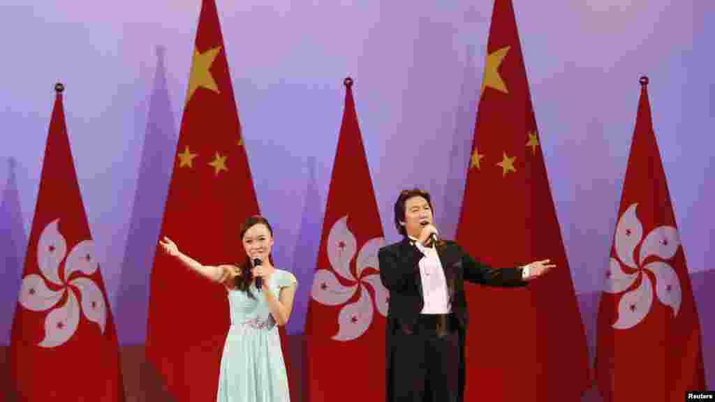Singers perform in front of Hong Kong and China flags during a reception following a flag-raising ceremony celebrating the 65th anniversary of China National Day in Hong Kong, Oct. 1, 2014 .