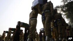 Pakistan soldiers carry the coffins of troops killed during an accidental NATO strike at a funeral in Peshawar, Pakistan, Nov. 27, 2011.