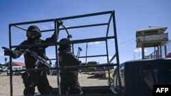 Policías escoltan los vehículos que transportaban al destituido jefe del ejército boliviano, Juan José Zúñiga, y a otros dos oficiales militares durante su traslado a una prisión de máxima seguridad en las afueras de El Alto, Bolivia, el 29 de junio de 2024.