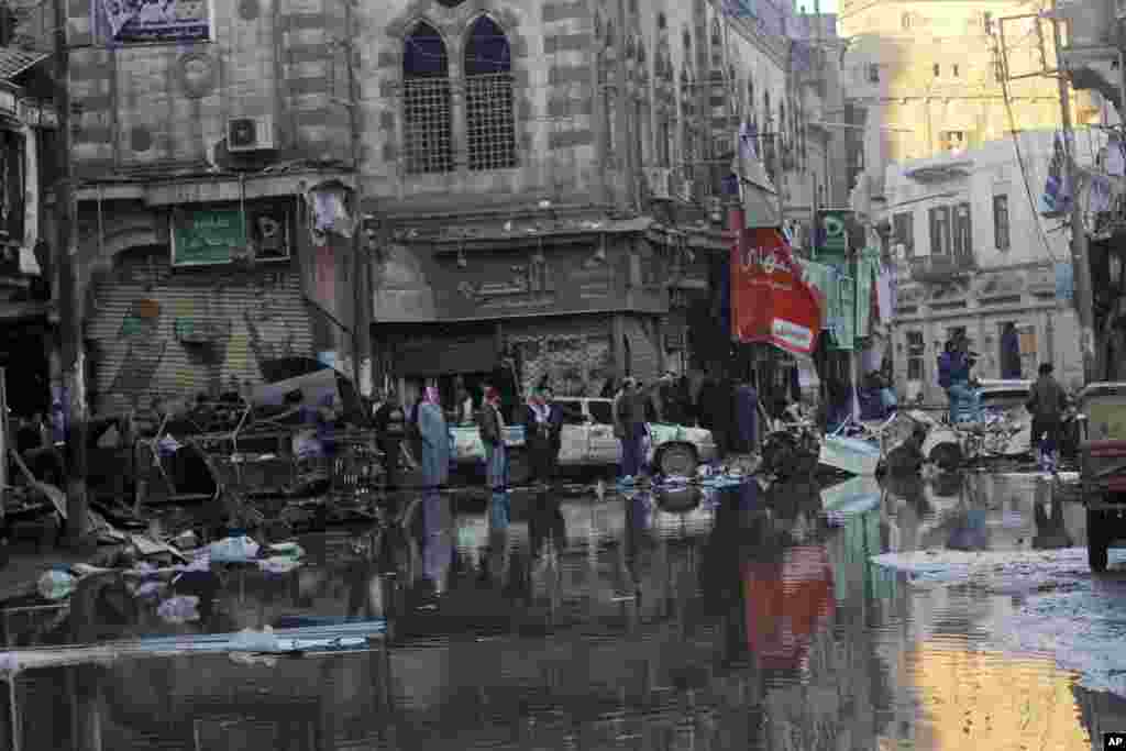 People gather after an explosion at a police headquarters building in the Nile Delta city of Mansoura, Egypt, Dec. 24, 2013.