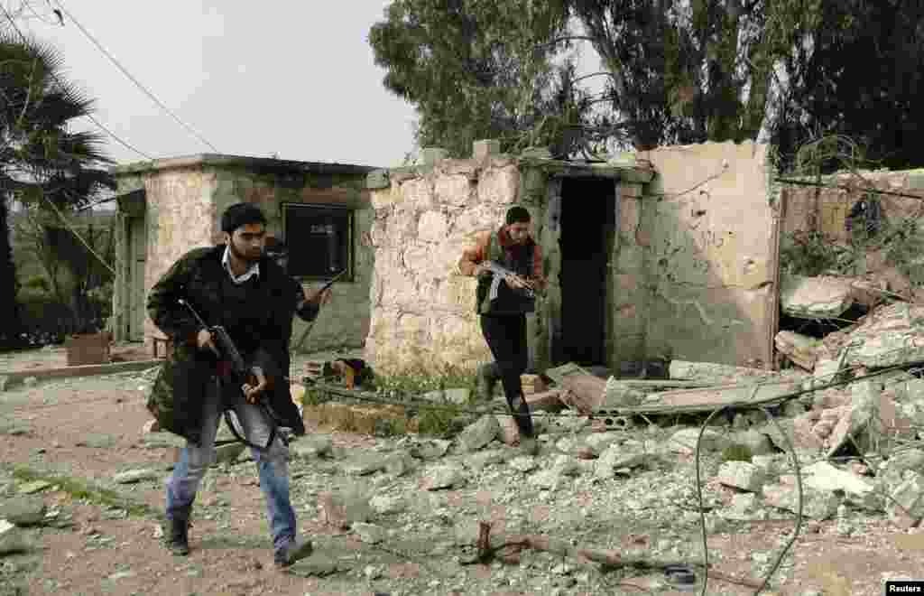 Free Syrian Army fighters carry their weapons and deploy after they seized control of the government's 80th Brigade's base near Aleppo International Airport, Feb. 23, 2013. 