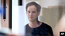 Jurnalis Wall Street Journal Evan Gershkovich berdiri di ruangan kaca di ruang sidang di pengadilan Kota Moskow di Rusia, pada 22 Juni 2023. (Foto: AP/Dmitry Serebryakov)