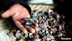 Un vendeur des minérais congolais montre des pierres précieuses dans une hutte de boue au Numbi dans l'est du Congo.