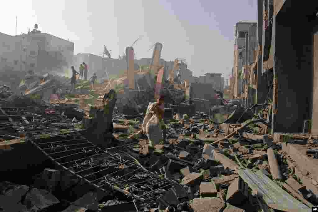 Palestinians look for their belonging after houses were destroyed in an Israeli strike in Rafah, southern Gaza Strip, Aug. 2, 2014.