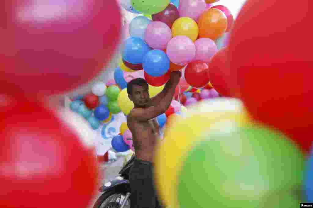 Seorang laki-laki mempersiapkan balon-balon untuk para pendukung Partai Rakyat Kamboja dalam acara kampanye pemilihan pada hari terakhir kampanye di pusat kota Phnom Penh. Kamboja akan mengadakan pemilu pada 28 Juli.