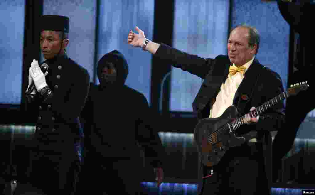 Pharrell Williams, left, performs "Happy" with composer Hans Zimmer at the 57th annual Grammy Awards in Los Angeles, California, Feb. 8, 2015.