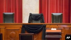 Kursi di Mahkamah Agung yang biasa ditempati oleh Hakim Agung Antonin Scalia ditutupi kain hitam untuk memberikan penghormatan padanya.