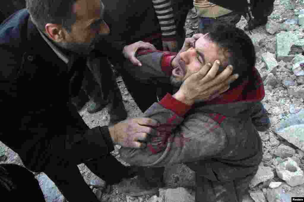 A man reacts after what activists said was an air raid by forces loyal to Syrian President Bashar Al-Assad in Aleppo's al-Marja district. More than 300 people have been killed in a week of air raids on the northern city of Aleppo and nearby towns, a monitoring group said.