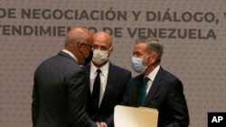 ARCHIVO - El presidente de la Asamblea Nacional de Venezuela, Jorge Rodríguez, a la izquierda, estrecha manos con el delegado de la oposición venezolana Gerardo Blyde Pérez en Ciudad de México, el 13 de agosto de 2021. 
