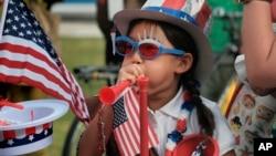 Hana Cho, 8 tahun, dari Pramuka Putri Troop 5665 mencoba meniup terompet sebelum berpartisipasi dalam pawai Hari Kemerdekaan 4 Juli di Santa Monica, 4 Juli 2017.
