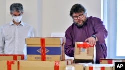 FILE— In this May 11, 2021 file photo, election auditors Harri Hursti, right, and Mark Lindeman, catalog ballot boxes in Pembroke, N.H., during a forensic audit of the 2020 New Hampshire legislative election. 
