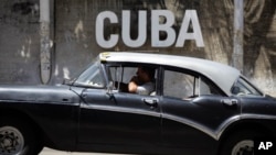 Un taxista cubano pasa frente al Centro Cultural en La Habana.