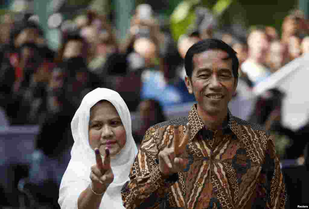 Kandidat presiden Joko "Jokowi" Widodo dan istri Iriana berpose setelah memberikan suara di Jakarta Pusat (9/7). (Reuters/Darren Whiteside)