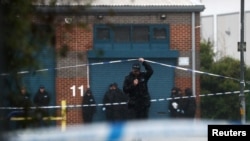 A police officer moves the tape inside the cordon, at the scene where bodies were discovered in a lorry container, in Grays, Essex, Britain, Oct. 24, 2019.
