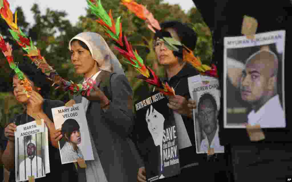 Indonesian activists hold portraits of inmates, all convicted on drug charges, during a demonstration to demand the government to stop the execution of them, in Jakarta, Indonesia, April 28, 2015.