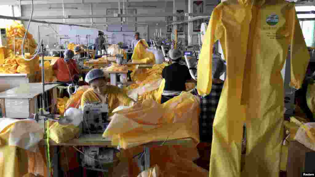 Workers make protective clothing at a factory of Lakeland Industries in Weifang, Shandong province, Oct. 28, 2014.