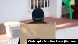 Um agente da polícia descarrega o voto antecipado numa urna na sede da Comissão Nacional Eleitoral em Bissau. Eleições Presidencias da Guiné-Bissau. 21 de Novembro 2019