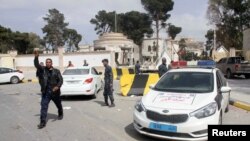Seorang anggota pasukan keamanan Libya memberikan isyarat setelah kelompok bersenjata pendukung pemerintah yang didukung PBB mengambil alih sebuah kompleks yang ditempati oleh seorang yang menyatakan diri sebagai perdana menteri dalam pertempuran sengit, di Tripoli, Libya, 15 Maret 2017. (Foto: dok)