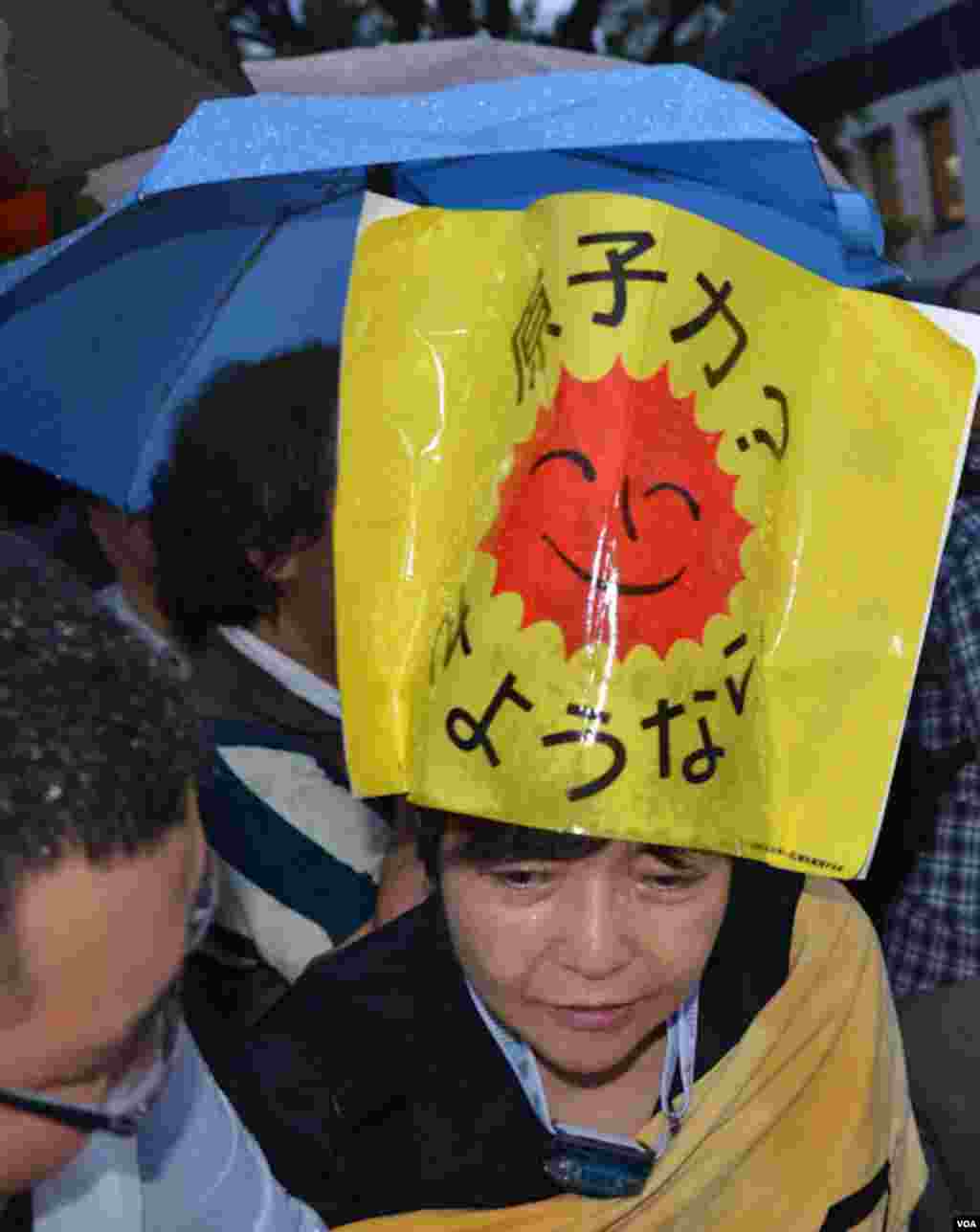 A rain-soaked protester, Tokyo, Japan, July 6, 2012. (S.L. Herman/VOA)