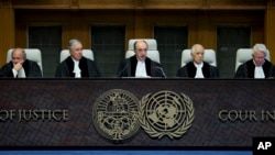 Presiding judge Peter Tomka, center, of Slovakia starts reading the World Court's decision in The Hague, Netherlands, Feb. 3, 2015. 