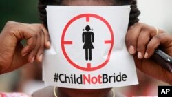 FILE - A woman protests against underage marriages in Lagos, Nigeria, July 20, 2013.