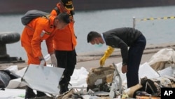 Un investigador (derecha) examina partes del vuelo 610 de Lion Air recogidos de las aguas cerca de Tanjung Priok, en Yakarta, Indonesia, el miércoles, 31 de octubre de 2018.