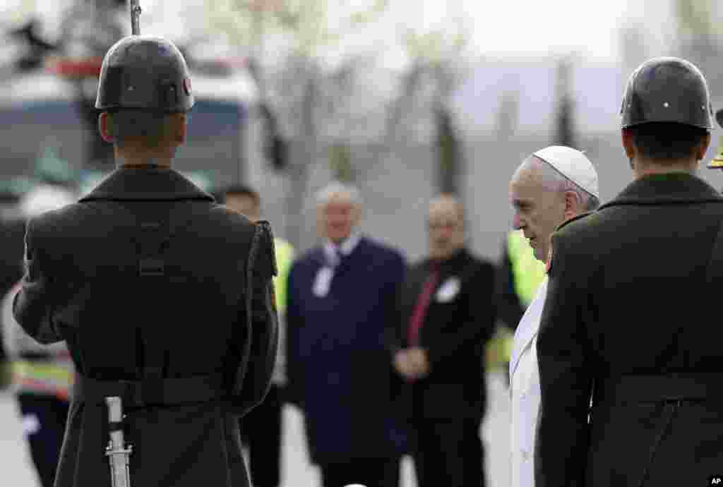 Paus Fransiskus berjalan melewati pengawal khusus ketika tiba di bandara Esenboga di Ankara, Jumat, 28 November 2014.