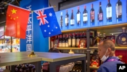 Seorang pengunjung melihat-lihat anggur Australia yang dipamerkan di sebuah pameran internasional di Shanghai, China, 5 November 2020. (Foto: Mark Schiefelbein/AP Photo)