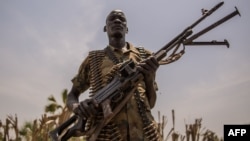 A rebel soldier poses with his gun in Touch Riak, Leer county, on March 7, 2018, where famine has been declared since February 2017.