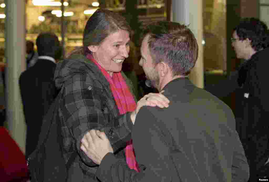 Greenpeace employee Daphane Christelis (L) greets Greenpeace activist Phillip Ball as he arrives at St. Pancras station in central London, England, Dec. 27, 2013.