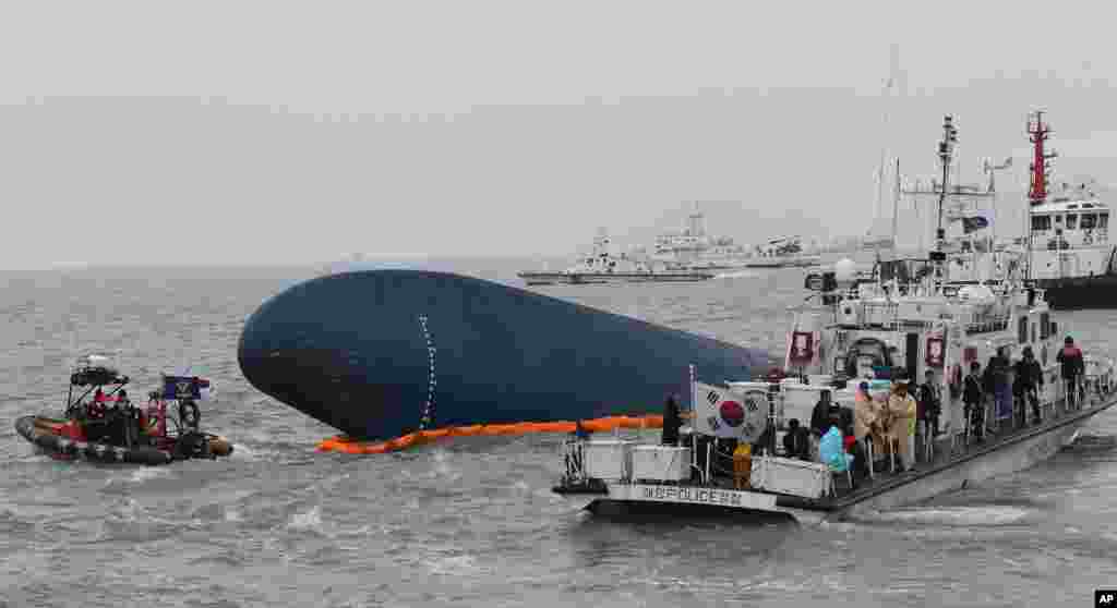 South Korean Coast Guard officers try to rescue missing passengers from a sunken ferry in the water off the southern coast near Jindo, South Korea, April 17, 2014. 