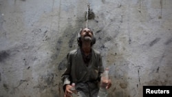 A man cools off from a public tap after filling bottles during intense hot weather in Karachi, Pakistan, June 23, 2015.