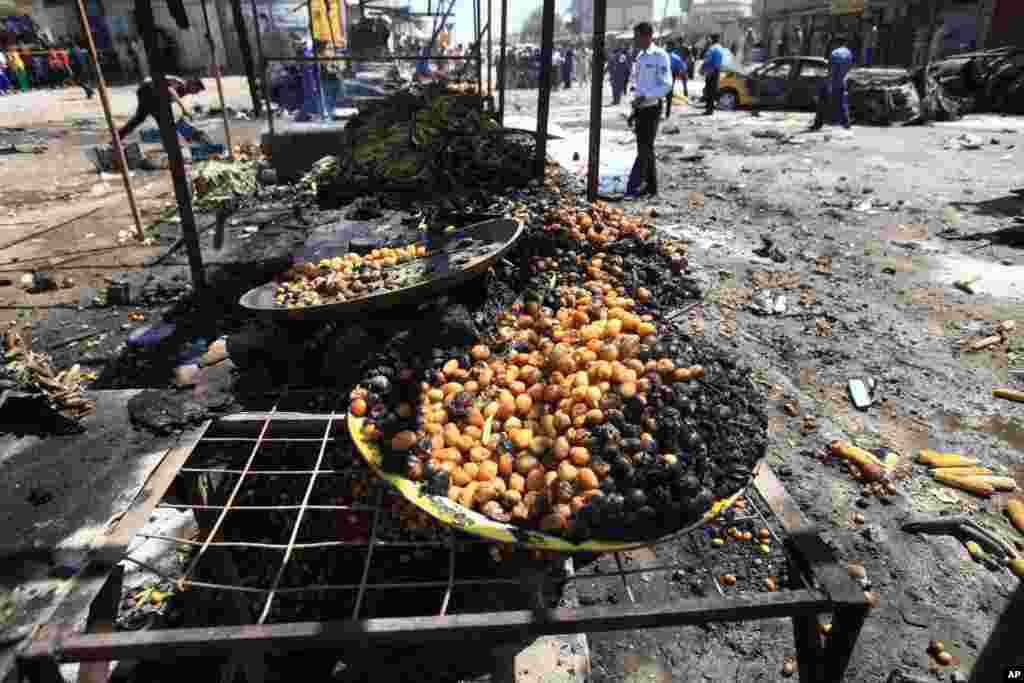People look at the site of a car bomb attack at a vegetable market in Basra, Sept. 15, 2013.