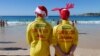 FILE - Volunteer life guards from North Bondi Surf Life Saving Club, keep an eye on swimmers enjoying Christmas day on Bondi Beach, Sydney, Dec. 25, 2018. Australia sweated through one of its hottest Decembers ever, and January wasn't any better.