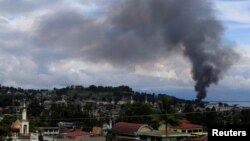 Black smoke comes from a burning building in Marinaot town, after government troops' continuous assault with insurgents who have taken over large parts of the city, in Marawi City, southern Philippines, May 26, 2017. 