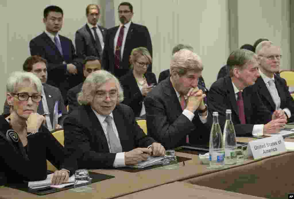 Di tengah semakin dekatnya tenggat negosiasi nuklir, Menteri Luar Negeri AS John Kerry (tengah) dan Menteri Luar Negeri Inggris Philip Hammond (kedua dari kanan) menunggu bersama para pejabat dari Rusia, China, Perancis, Jerman, Uni Eropa dan Iran di Hotel Beau Rivage Palace Hotel di Lausanne, Swiss (30/3). (AP/Brendan Smialowski)