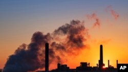 FILE - The Dave Johnson coal-fired power plant is silhouetted against the morning sun in Glenrock, Wyoming, July 27, 2018. The Trump administration has loosened rules for oil and gas companies to control leaks of methane, a potent greenhouse gas. 