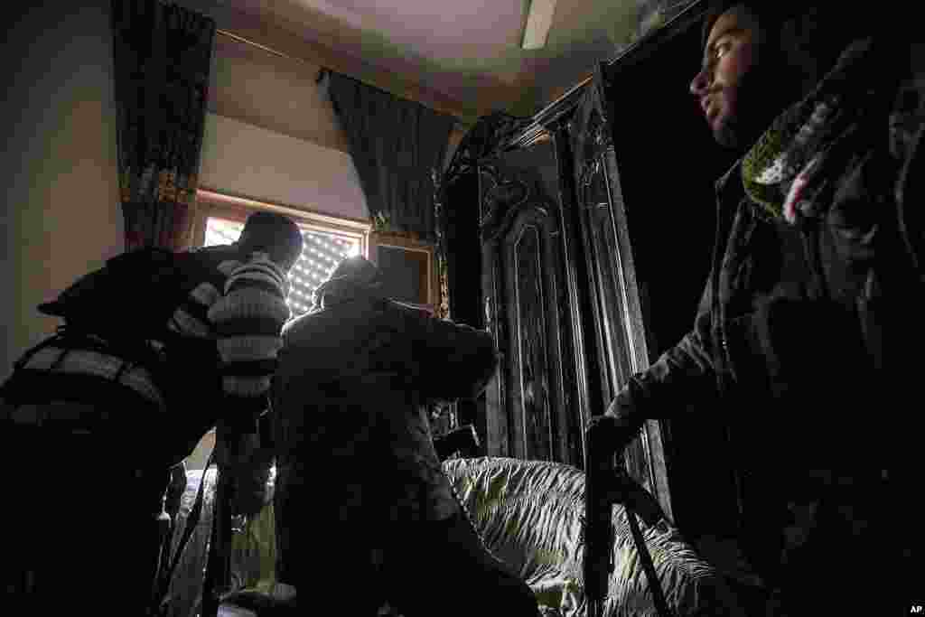 Free Syrian Army fighters look for government forces during heavy clashes in Aleppo, Syria, December 11, 2012.