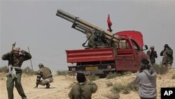 Libyan rebels prepare to fire a rocket launcher at the front line outside Brega, April 2, 2011