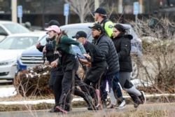 King Soopers employees are led away from an active shooter at the King Soopers grocery store in Boulder, Colorado, March 22, 2021. Police say 10 people were killed in the shooting, including a police officer.