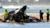 Petugas darurat memeriksa helikopter di tempat kejadian tabrakan dekat Seaworld, di Gold Coast, Australia, Senin, 2 Januari 2023. (Foto: via AP)