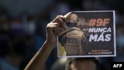 Un manifestante sostiene una pancarta que dice "# 9F nunca más" durante una manifestación contra el presidente Nayib Bukele, un año después de la incursión militar a la Asamblea Legislativa, en San Salvador, el 9 de febrero 2021.