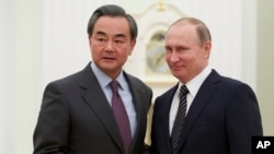 2016年3月11日，俄罗斯总统普京（右）在莫斯科与中国外长王毅握手。（资料照片）