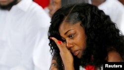 Myeshia Johnson, Janda Sersan AD La David Johnson, satu di antara empat tentara pasukan khusus yang terbunuh di Niger, duduk dengan putrinya, Ah'Leeysa Johnson pada upacara pemakaman di Hollywood, Florida, 21 Oktober 2017.
