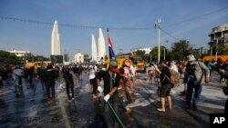 Para demonstran anti-pemerintah menyapu jalan di depan Monumen Demokrasi di Bangkok, Thailand (4/12). (AP/Vincent Thian)
