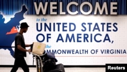 FILE - A man exits the transit area after clearing immigration and customs on arrival at Dulles International Airport in Dulles, Virginia, Sept. 24, 2017. 