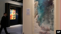 FILE - A man walks past the painting "Peach Blossom Spring" by Chinese artist Zhang Daqian during a preview for the Sotheby's Spring Sales in Hong Kong, April 1, 2016. 